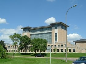 Modern institutional building with green lawn and exterior landscaping